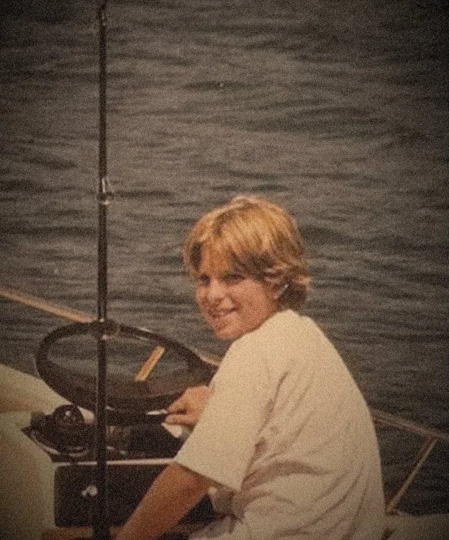 Kyle as a kid at the helm of the family boat